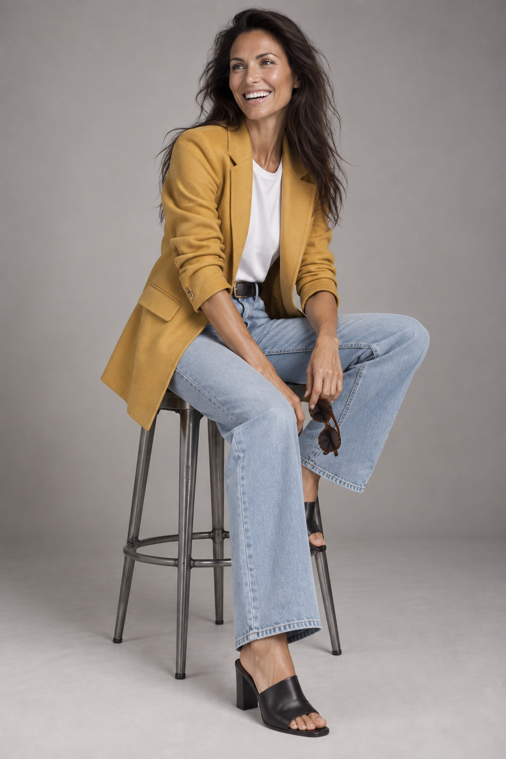 Lauren, female AI fashion model seated in a mustard-yellow blazer, white T-shirt and wide-leg jeans, fashion editorial by VIDA AI
