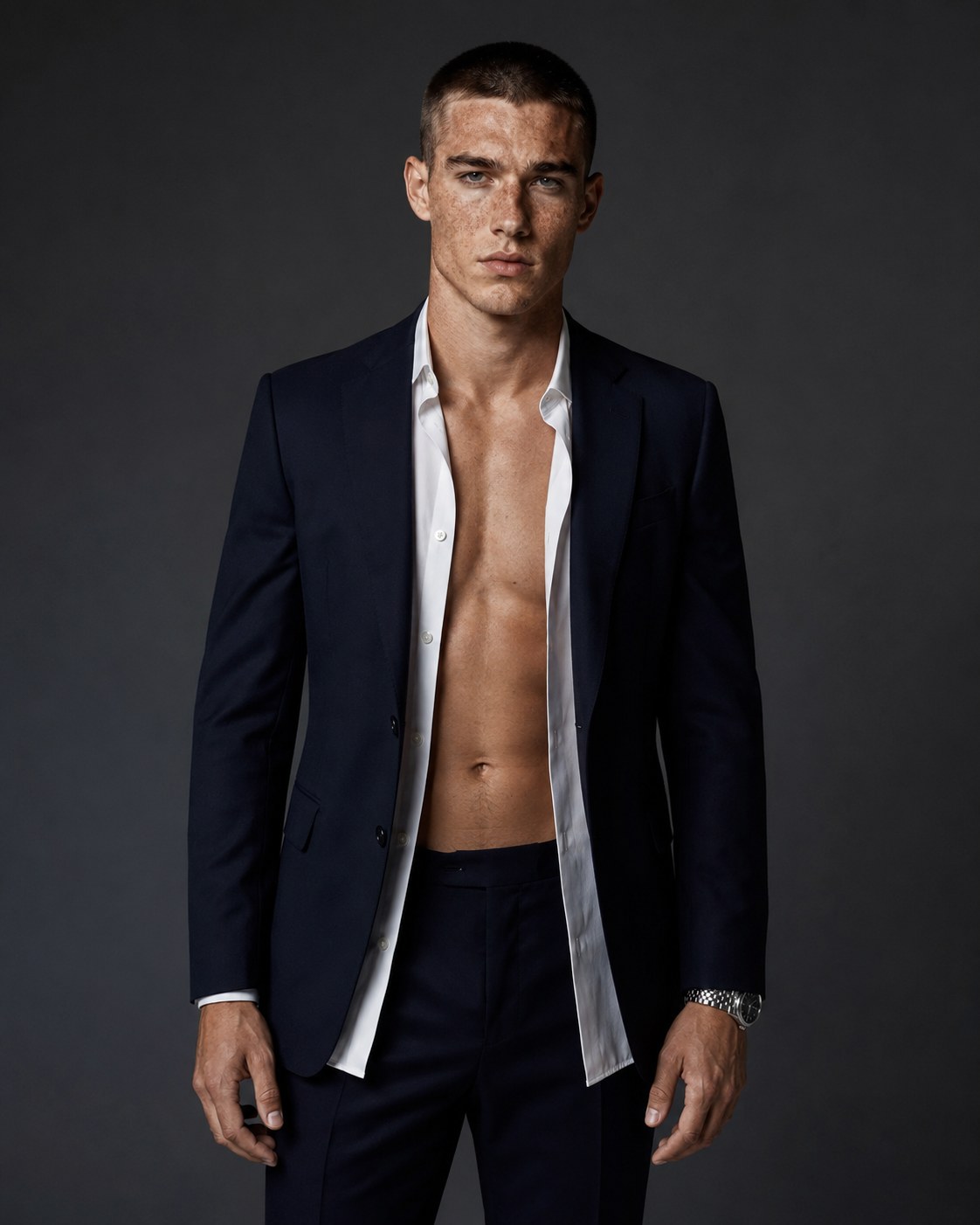 Chris, AI-generated male model in a navy tailored suit and open-collar white shirt, portrait against a dark studio background